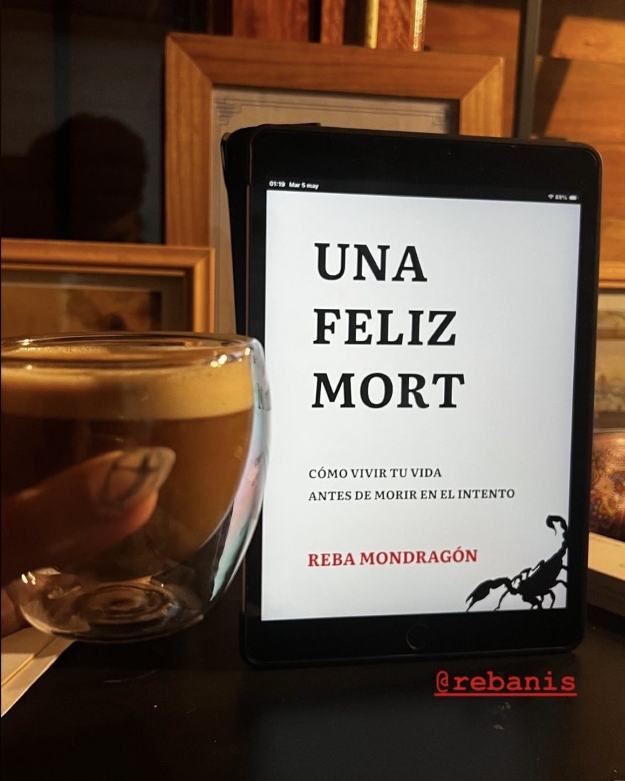 La portada del libro en una tablet, junto a un café